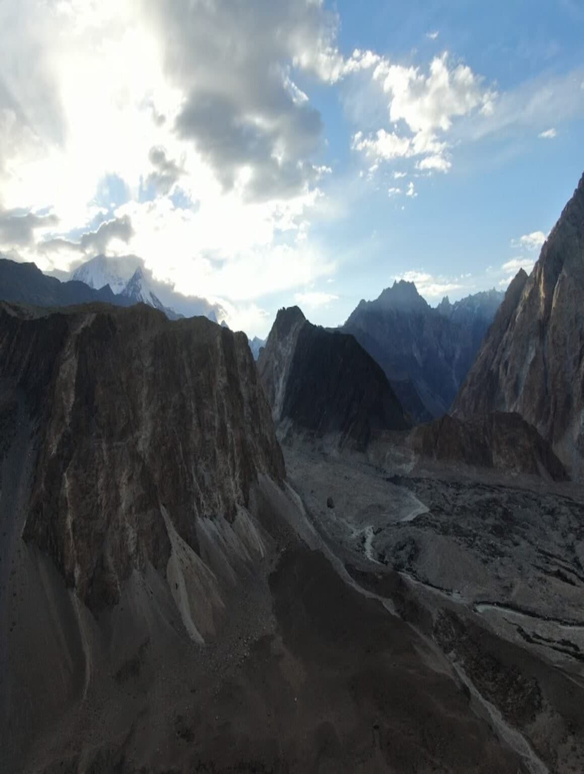 Aerial view of jagged Karakoram peaks catching evening light above a glacier valley