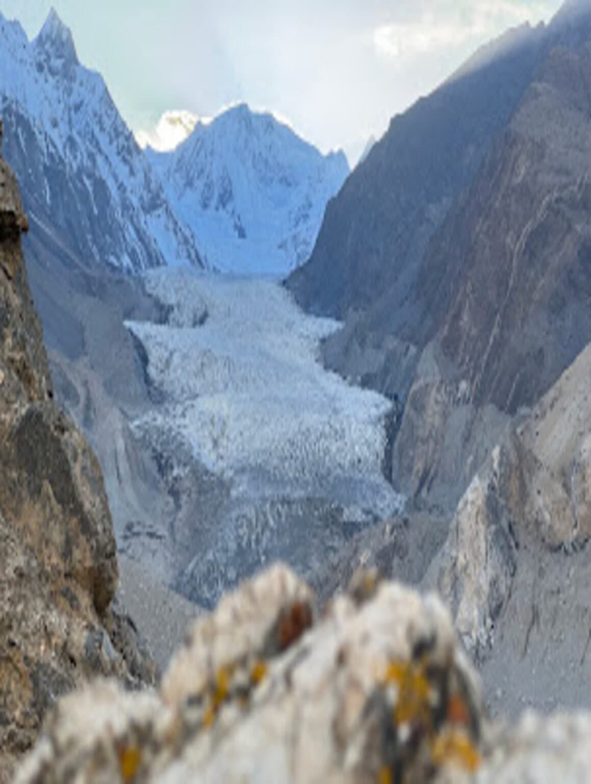 Close-up view of a glacier tongue descending between snow-capped peaks