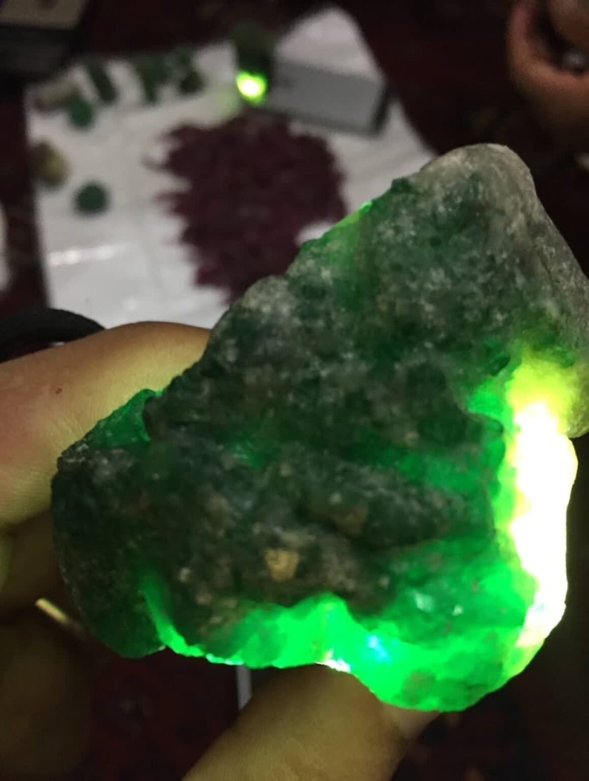 Close-up of a raw green crystal backlit to show its translucence