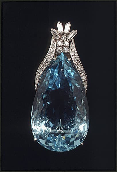 A faceted aquamarine gemstone set in a diamond pendant