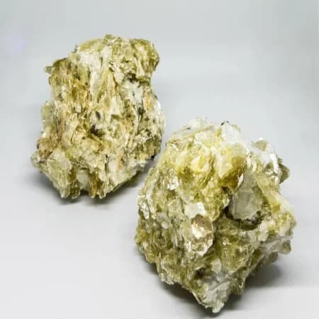 Two natural mica mineral specimen clusters showing sheet-like layered structure